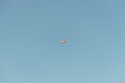 Free A small airplane captured mid-flight against a vast, clear blue sky, emphasizing freedom and travel. Stock Photo