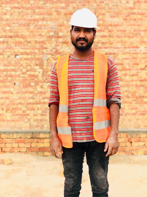 A Construction Worker Wearing Safety Gears Looking at the Camera
