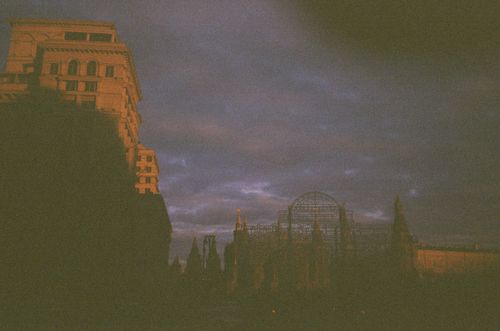 Free A vintage cityscape at dusk with a moody sky casting shadows on historic buildings. Stock Photo