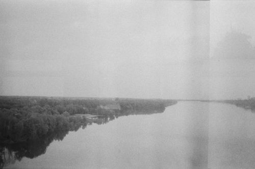 Free A calm monochrome view of a river and forest with a minimalistic feel. Stock Photo