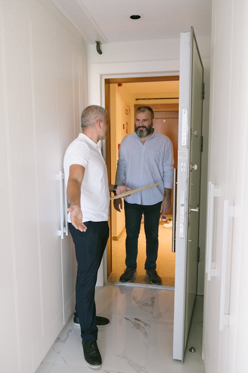 Free Two Men Standing by the Doorway Talking Stock Photo