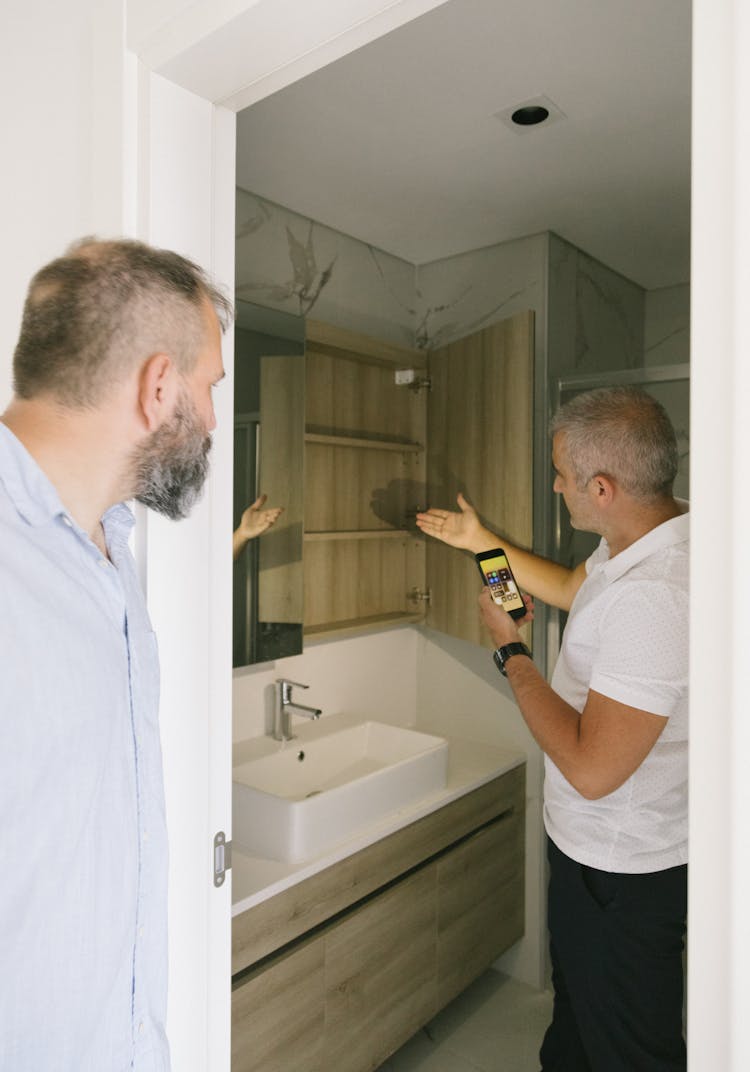 Men Looking Inside Of A Cabinet