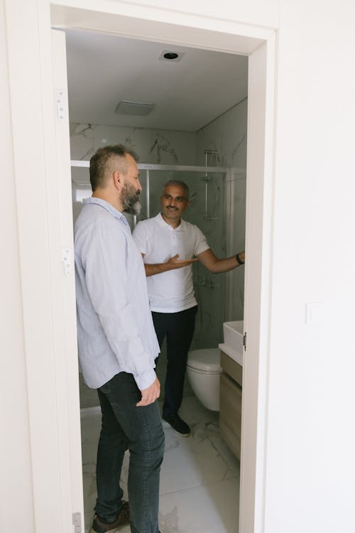 Two Men Looking Into a Bathroom