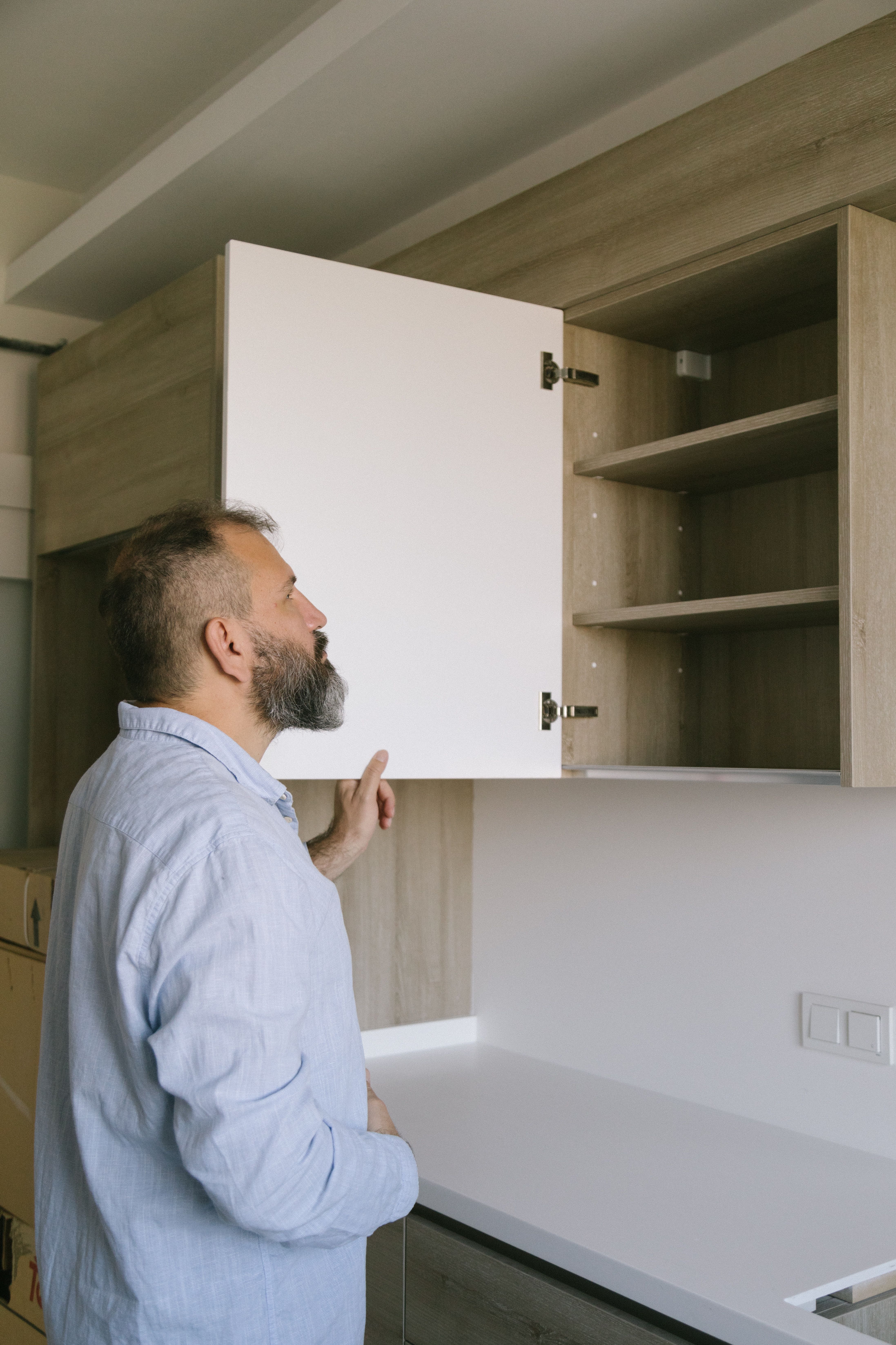 Person inspecting a cabinet—stand‑in for careful camera inspection before buying.