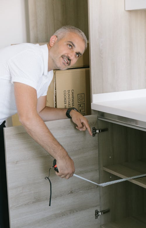 Man in White Polo Shirt Holding a Measuring Tape