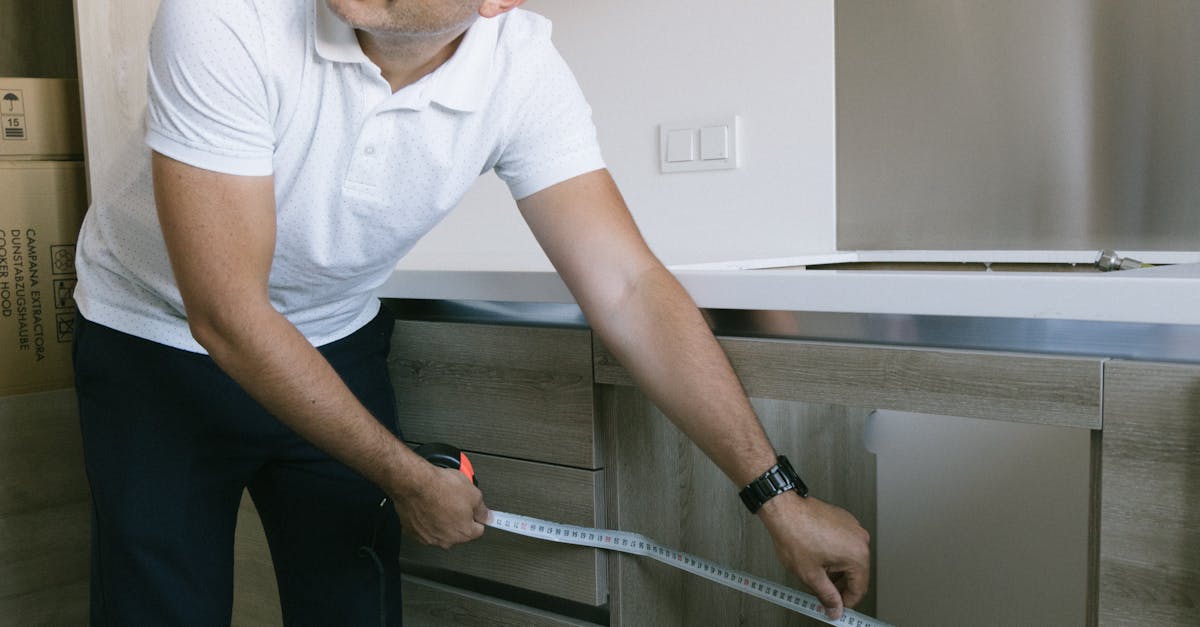 A woman painting a terracotta pot with colorful design using a paintbrush on a wooden table.