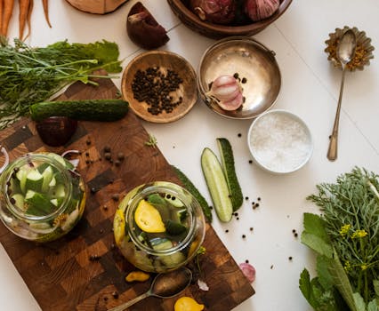 Aerial view of kitchen table with fresh vegetables and pickles preparation.