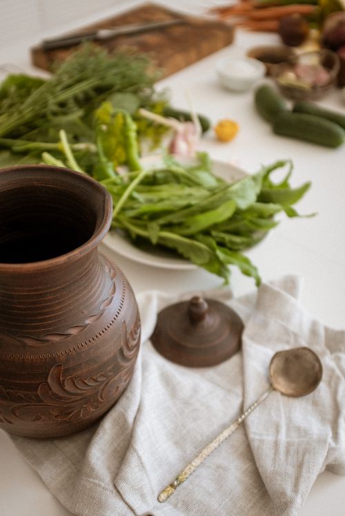 Free Rustic ceramic jar with fresh vegetables on a kitchen countertop, exuding organic charm. Stock Photo