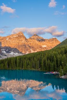 Pristine Moraine Lake reflecting stunning mountains and clear blue sky.