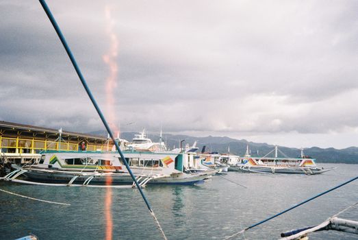 Traditional boats docked in Malay, Philippines under a cloudy sky. Ideal for travel enthusiasts.