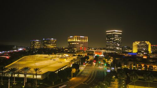 Free A nighttime cityscape featuring illuminated skyscrapers, streets, and traffic in a bustling urban area. Stock Photo