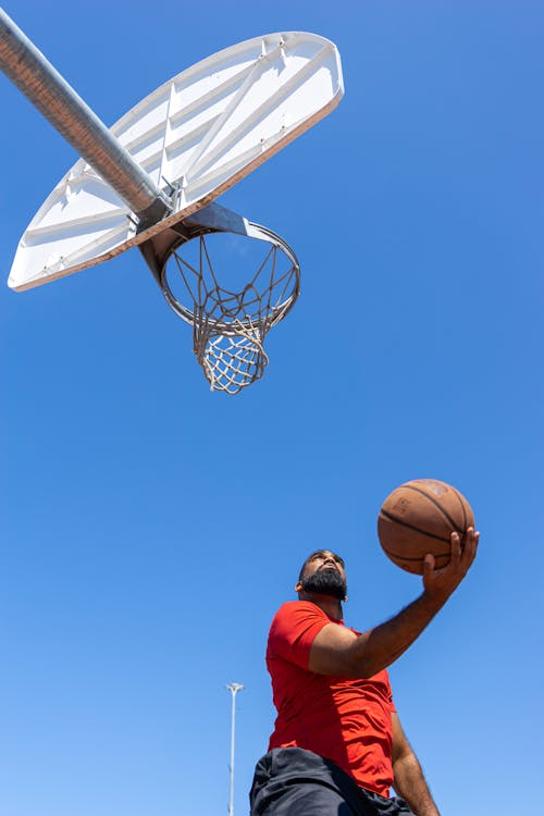 Man Holding a Basketball Looking on the Hoop