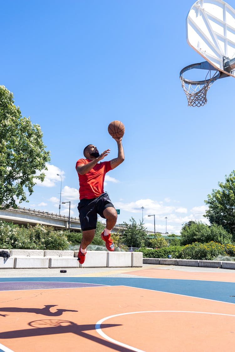 Man Holding A Ball Making A Layup