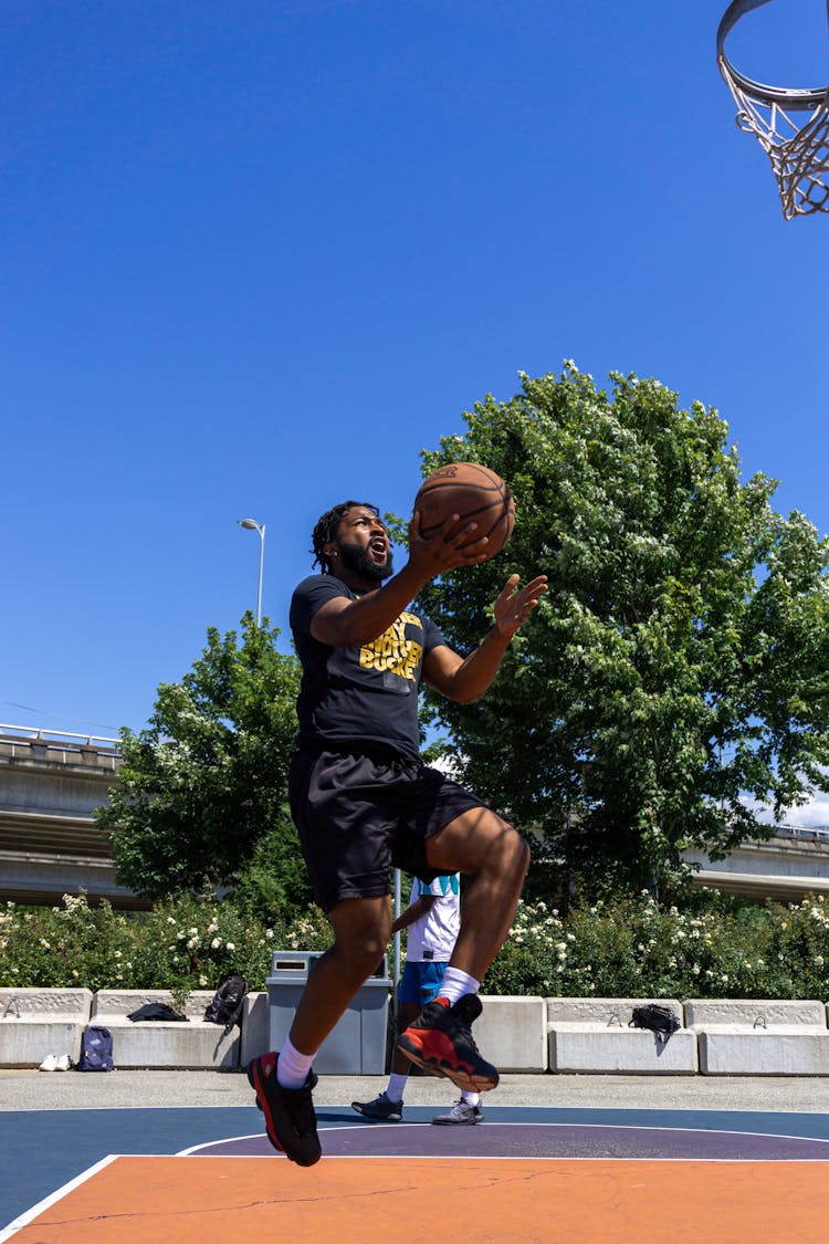 A Man In Black Shirt Playing Basketball