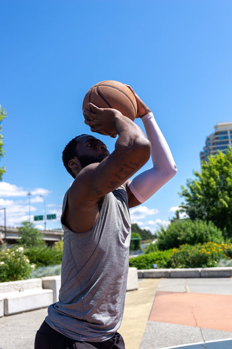 Man In Gray Tank Top Shooting A Ball 