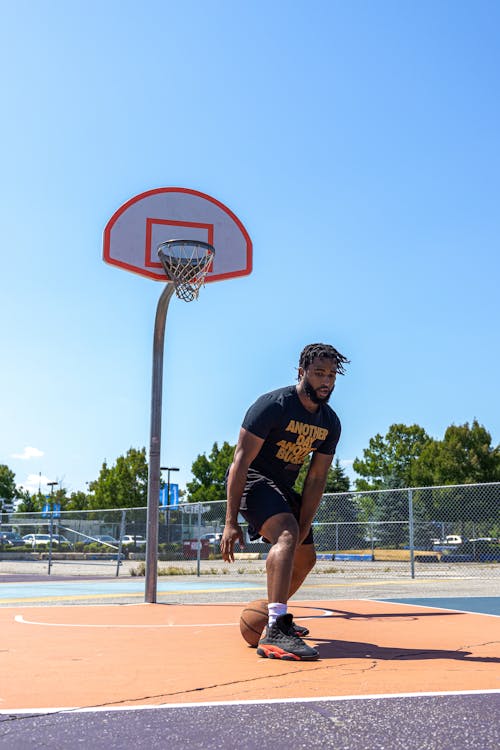 Man Dribbling a Basketball Between the Legs