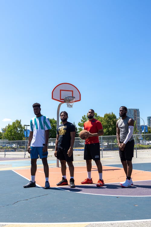  Basketball Players Standing on an Open Court while Seriously Looking at the Camera
