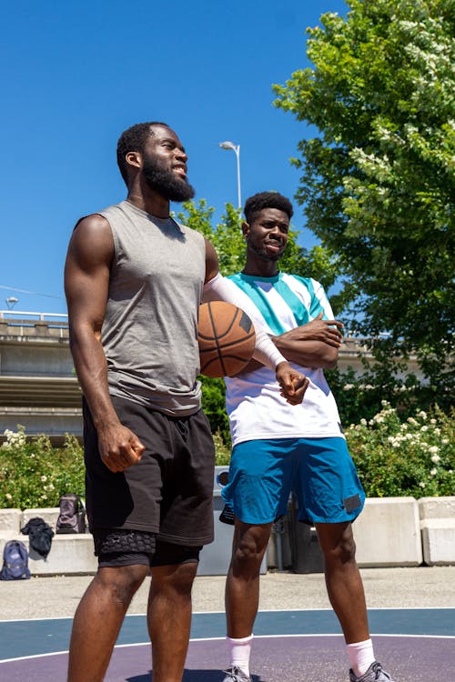 Free Basketball Players Standing Next to Each Other while Looking Afar Stock Photo