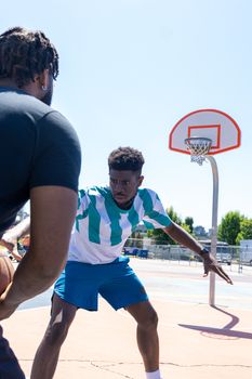 Two men playing competitive basketball on an outdoor court.