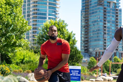 Free A Man in a Red Shirt Holding a Basketball Stock Photo
