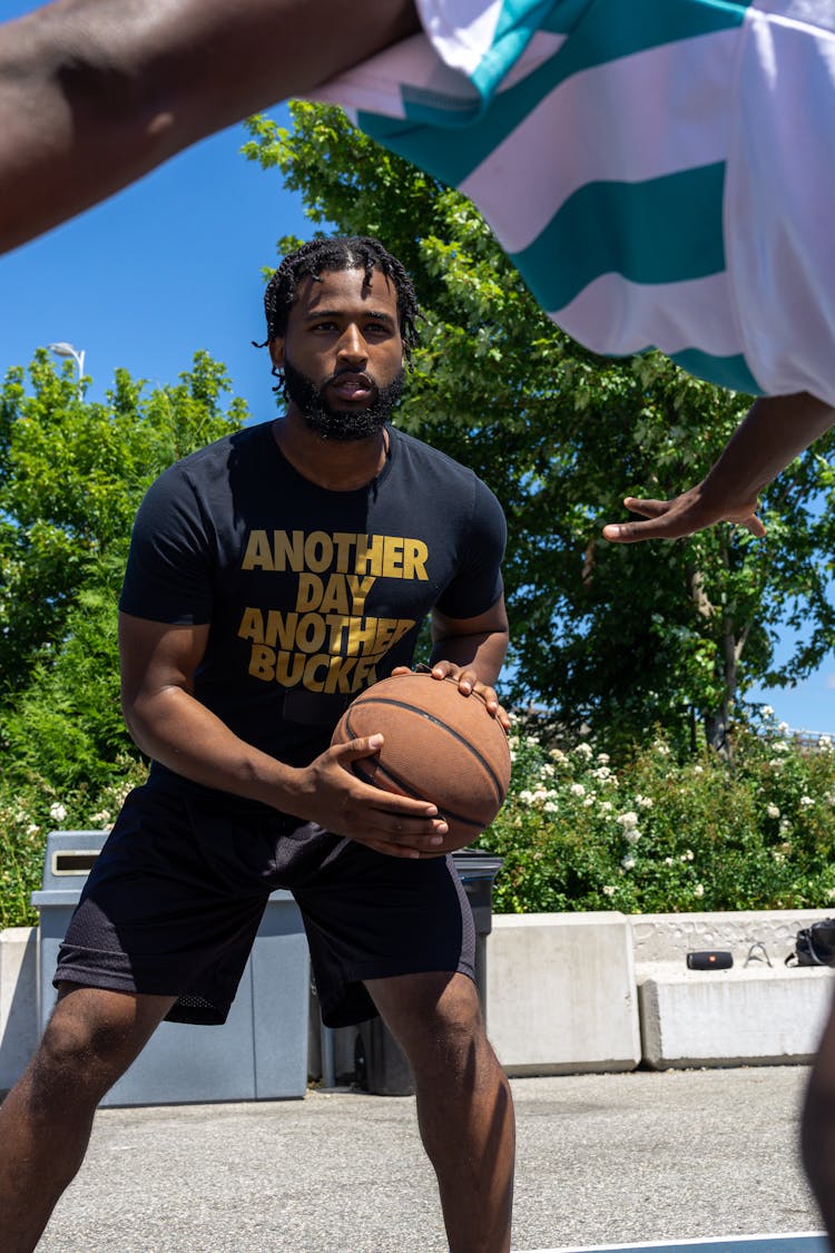 A Man In Black Shirt Playing Basketball Outdoors