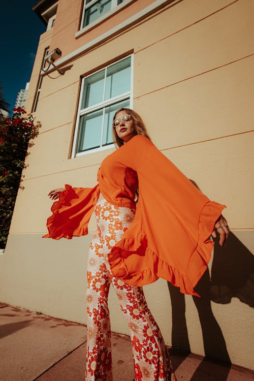 Stylish Woman Wearing an Orange Top and Floral Pants