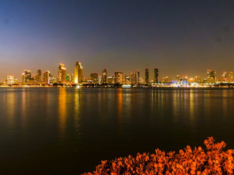 Stunning night view of San Diego skyline reflecting on the bay with city lights.