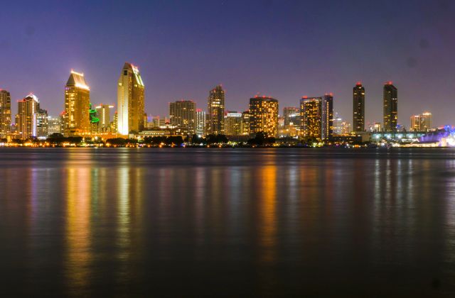 Stunning night view of San Diego's illuminated skyline with calm waterfront reflections. — arriving in San Diego