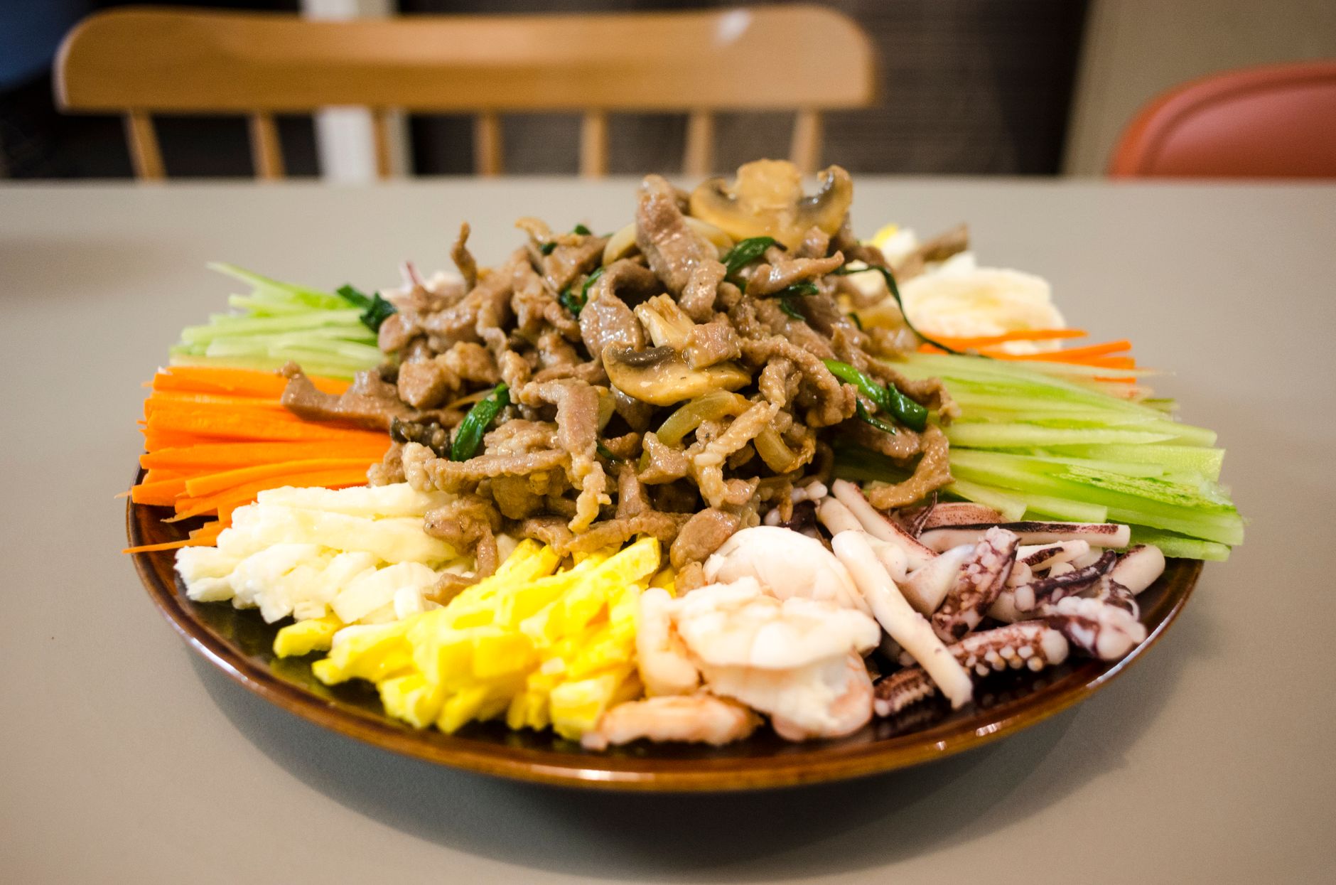 Vibrant Asian stir-fry platter with seafood and fresh vegetables, perfect for diverse culinary experiences.