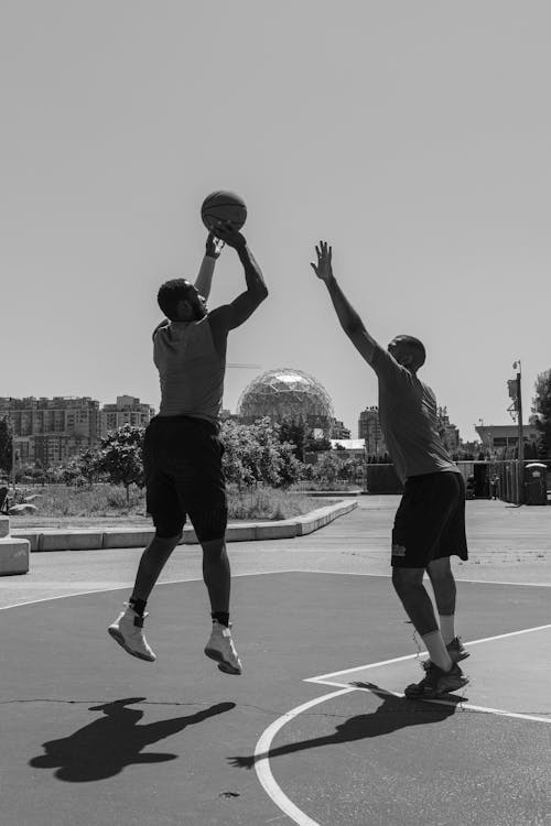 A Man in Midair Shooting a Ball