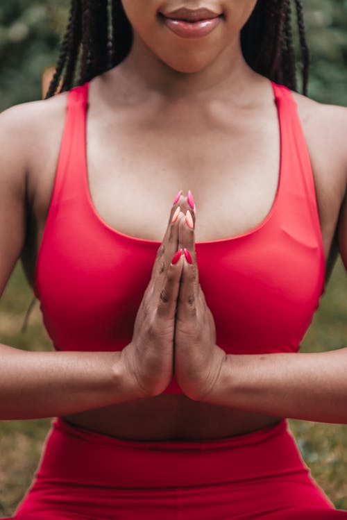 Close-Up Photo of Woman in Red Activewear Meditating
