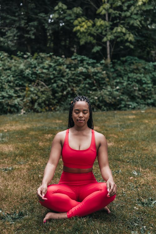 Woman in Red Activewear Sitting on the Grass · Free Stock Photo