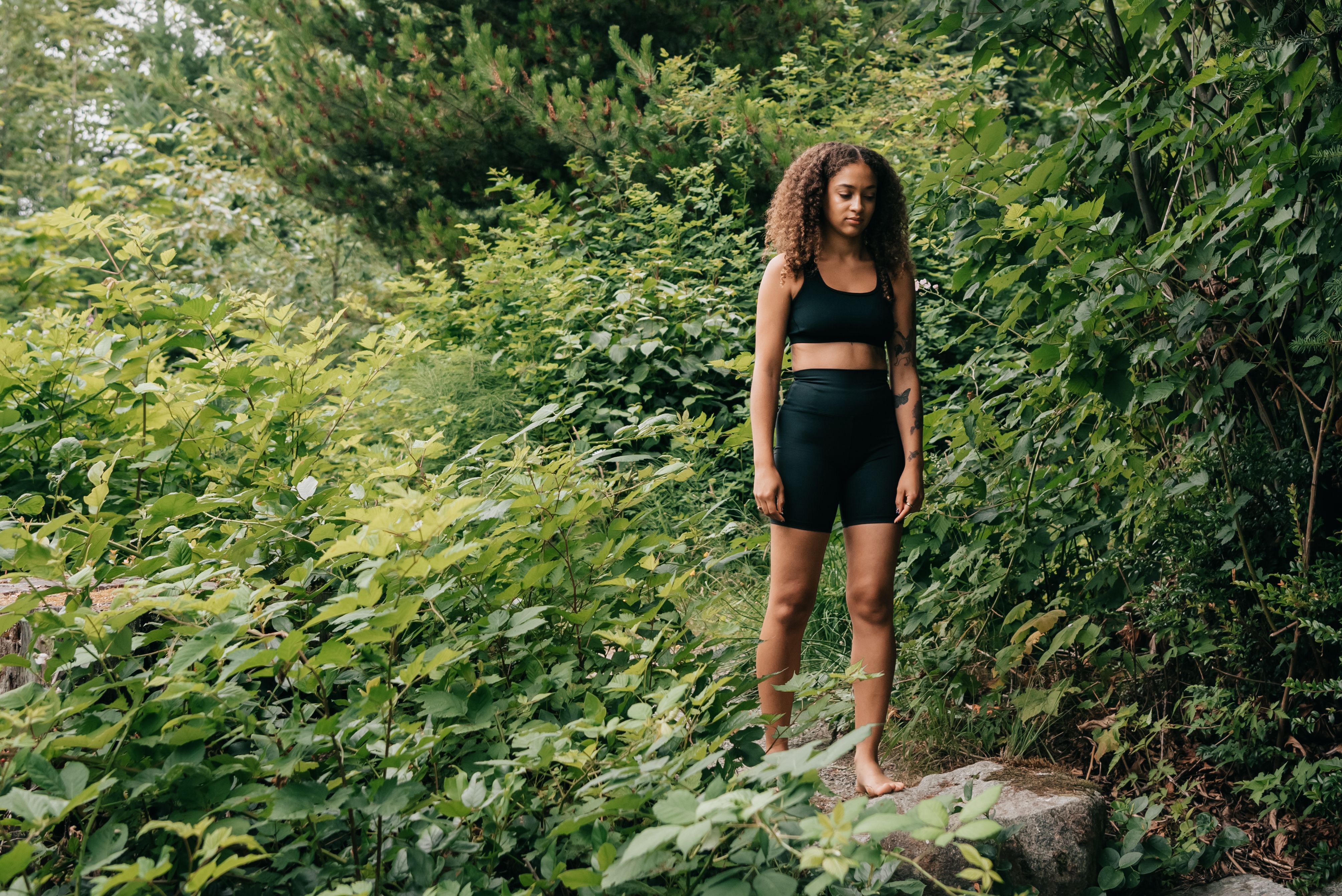 Woman standing barefoot in a forest practicing grounding during spiritual awakening
