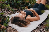 Woman in Black Sports Bra Lying on a Blanket