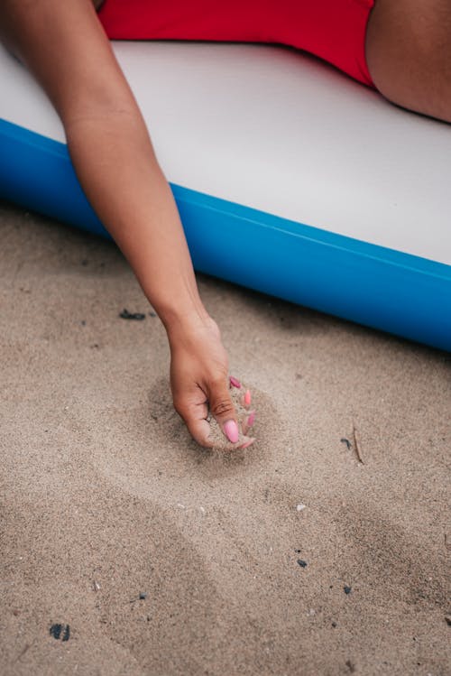 
A Woman with Manicured Nails Holding Sand