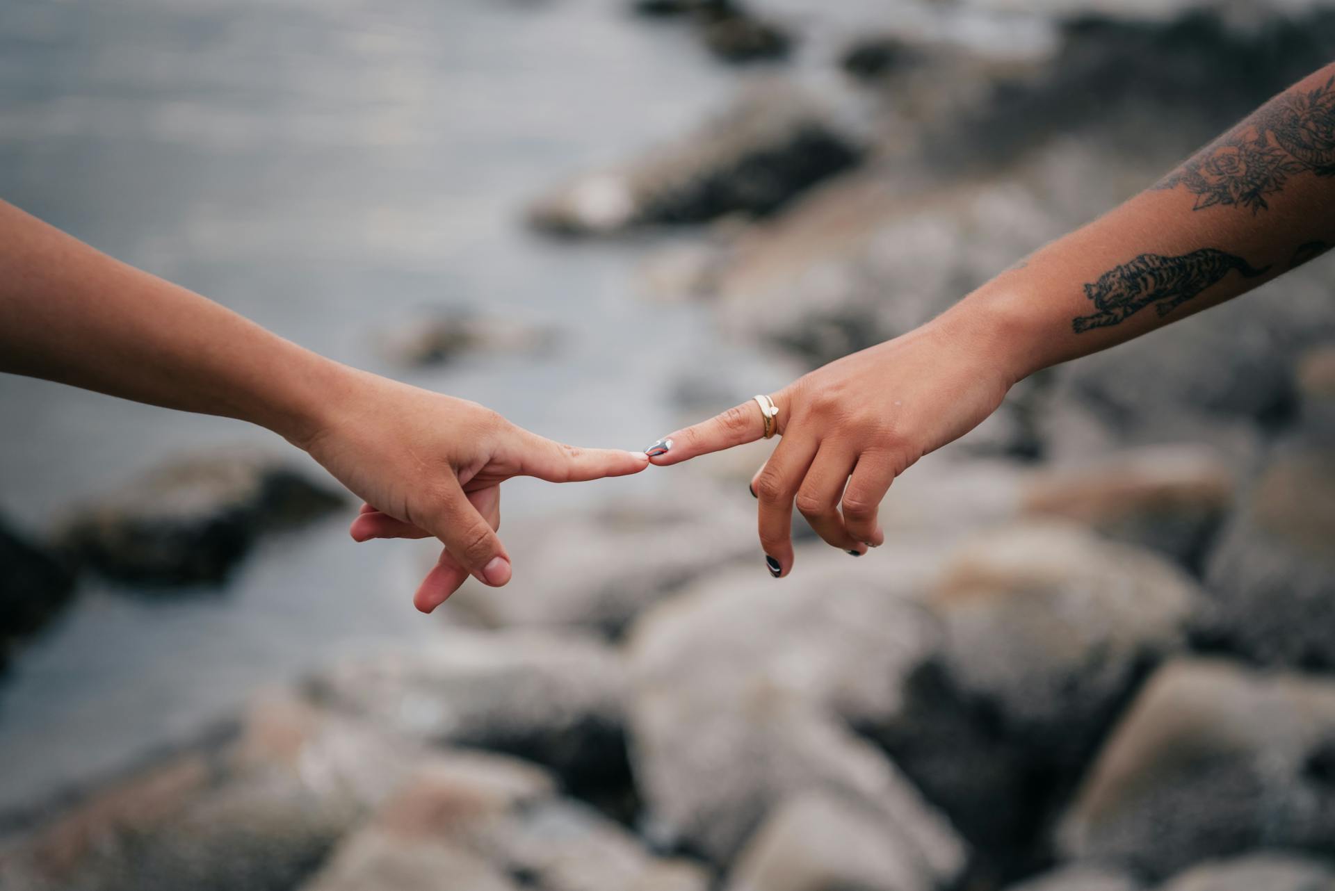 A close-up of two hands reaching out and almost touching, symbolizing connection.