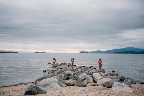 Free Women Standing on Rocky Shore while MEditating Stock Photo