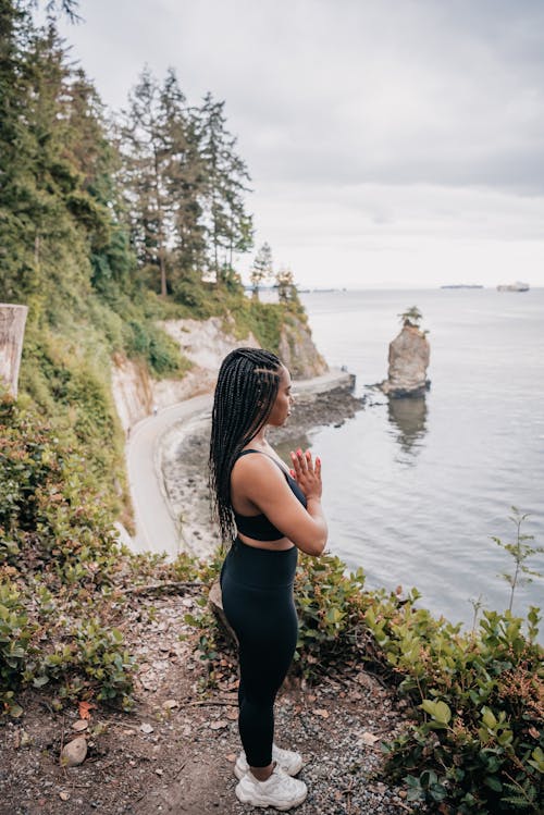 Free Woman in Black Activewear Standing while Meditating Stock Photo