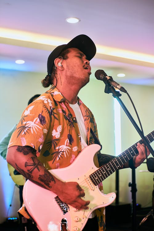 A Man Singing while Playing an Electric Guitar