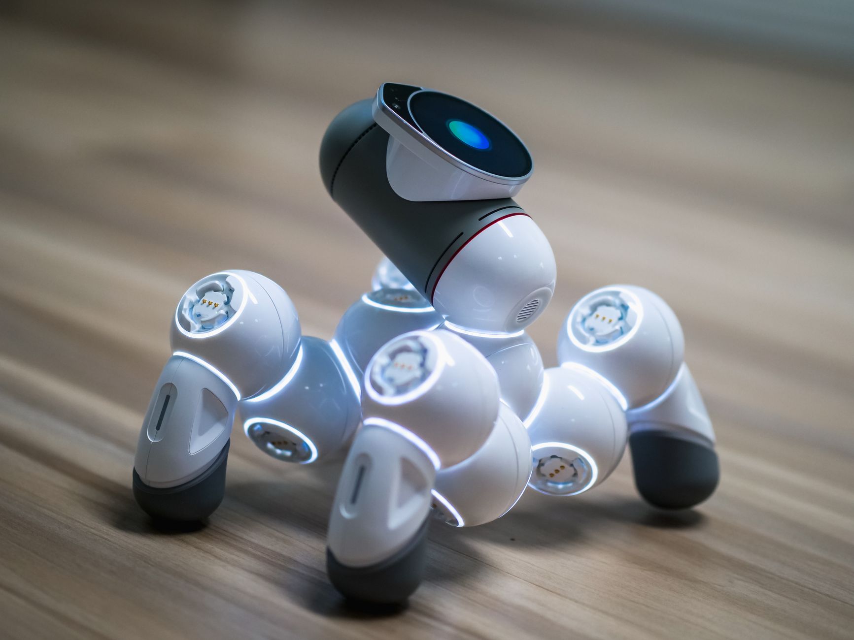 Close-up of a futuristic robot toy on a wooden floor, showcasing modern innovation.