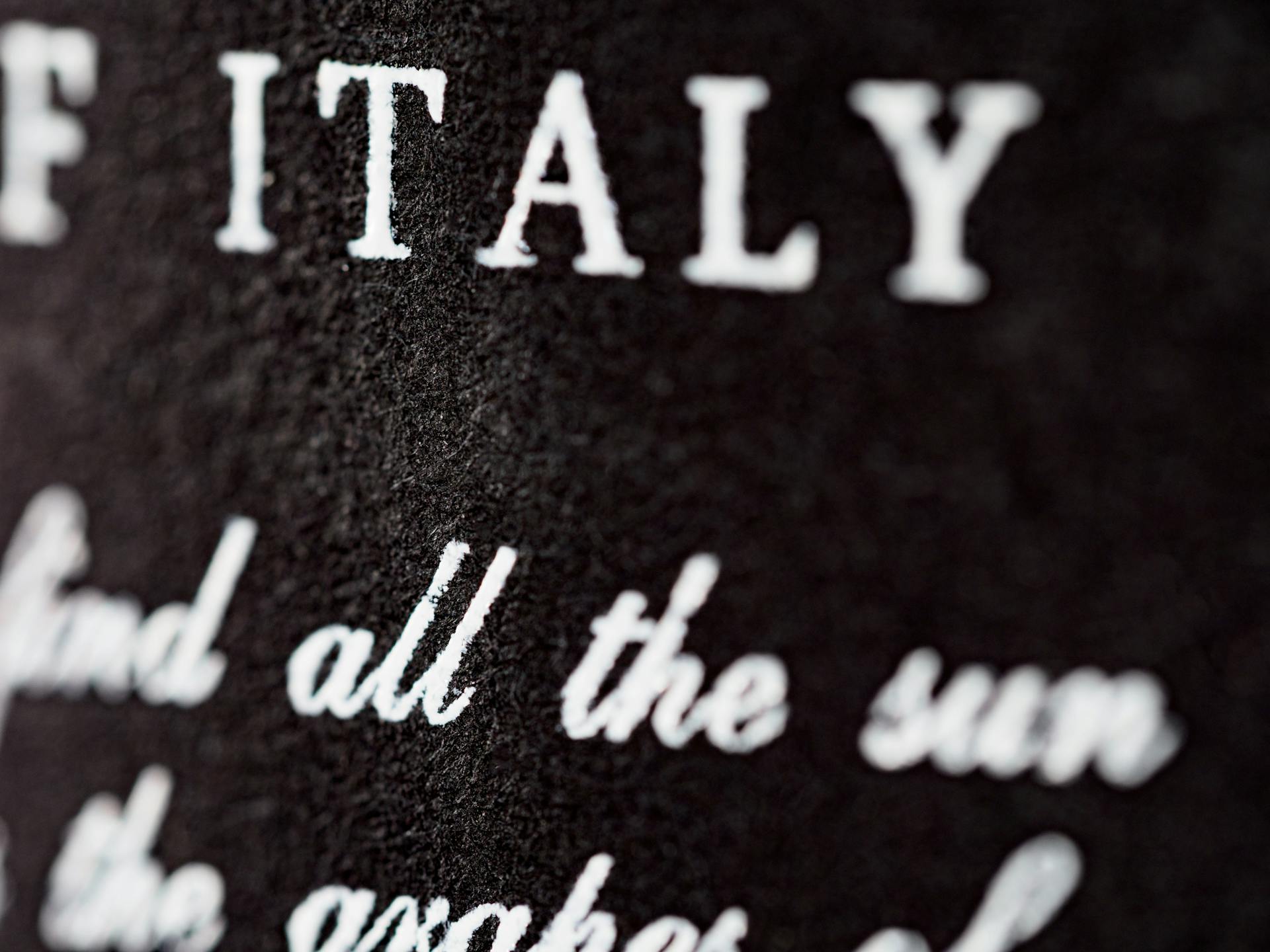 Detailed close-up of textured black surface with white typography 'ITALY.'