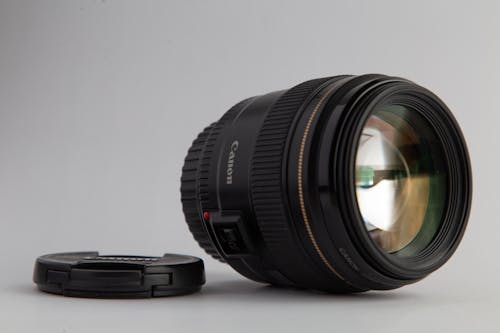 Free Close-Up Photo of Black Canon Dslr Camera Lens on White Surface Stock Photo