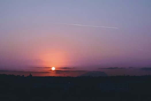 Silhouette of Sant Cugat del Vallès cityscape at sunset with vibrant skies.