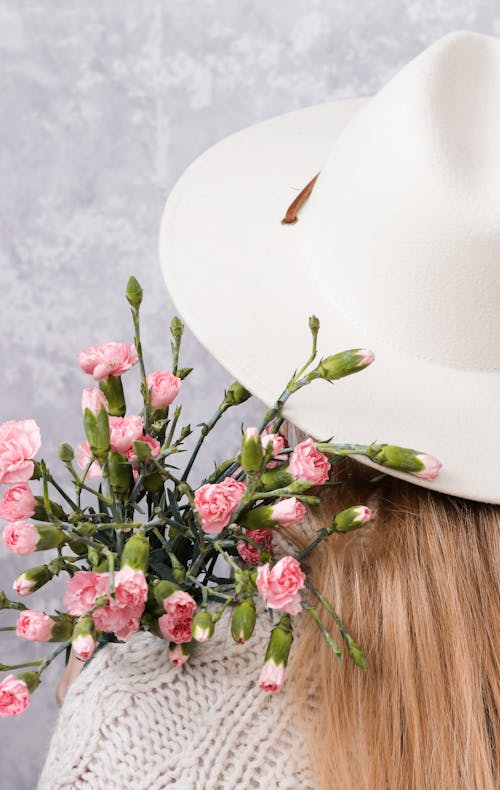 Free Person Wearing White Fedora Hat Holding Carnation Flowers  Stock Photo