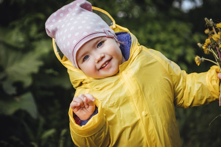 Child In Yellow Raincoat Smiling