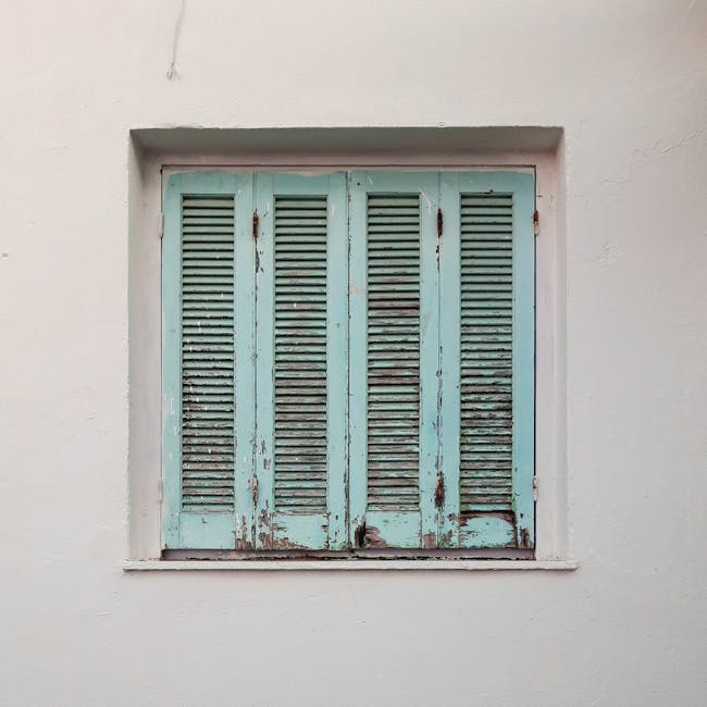 Textured vintage window with turquoise shutters on a white wall, Corfu, Greece
