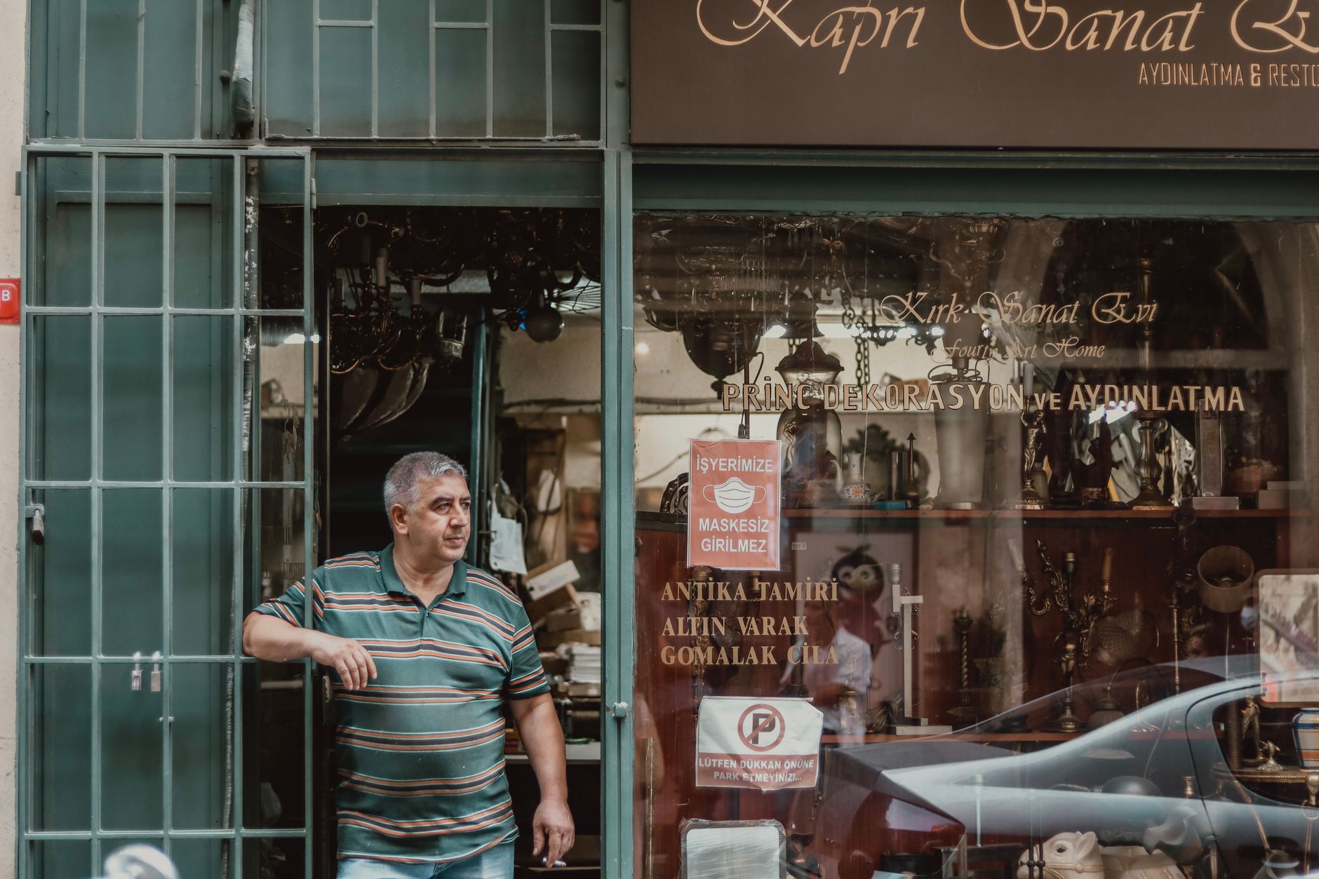 Bir dükkân kapısı önünde sigara içen genç kadın