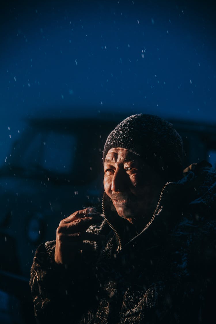 A Man Smoking A Cigarette While Snowing