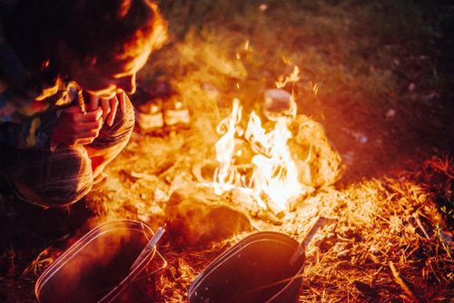 Free A person enjoys a warm campfire during an outdoor adventure in Russia's tranquil wilderness. Stock Photo
