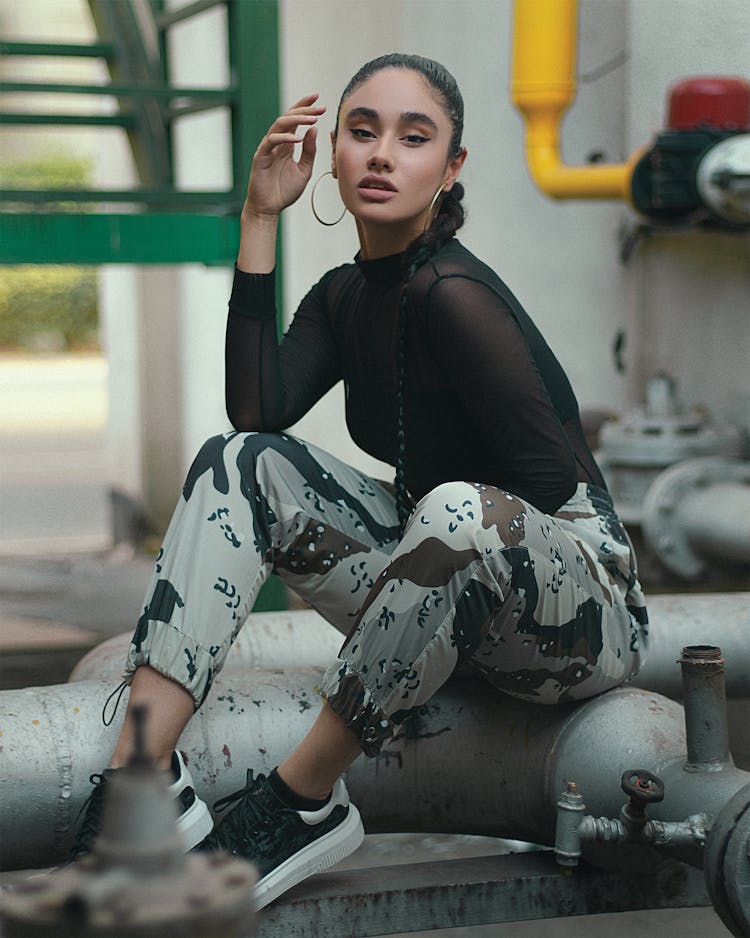 A Woman In Black Long Sleeves And Camouflage Pants